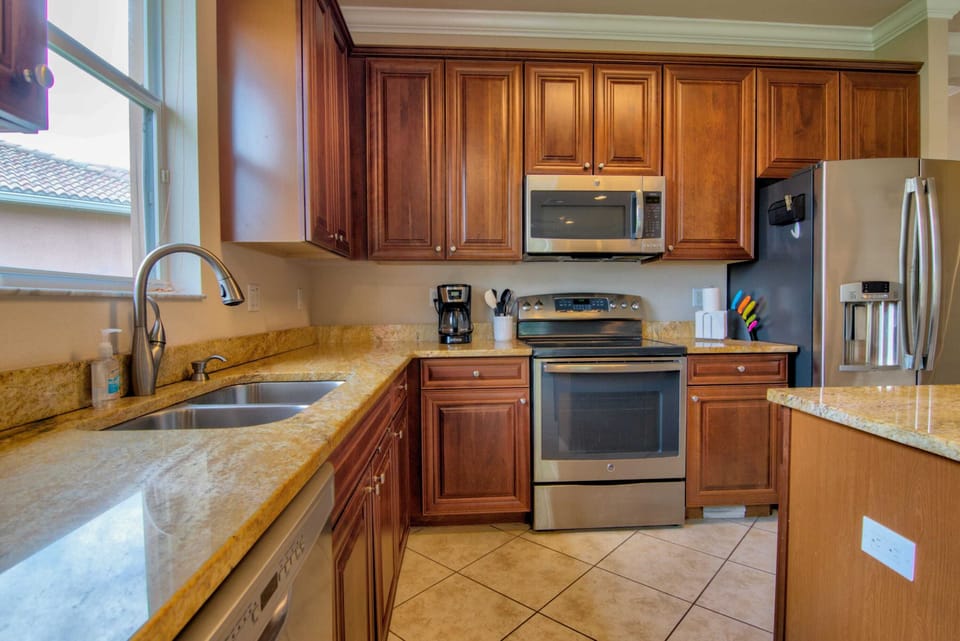The Kitchen Features Hardwood Cabinetry, Stainless Appliances and Granite Counter Tops