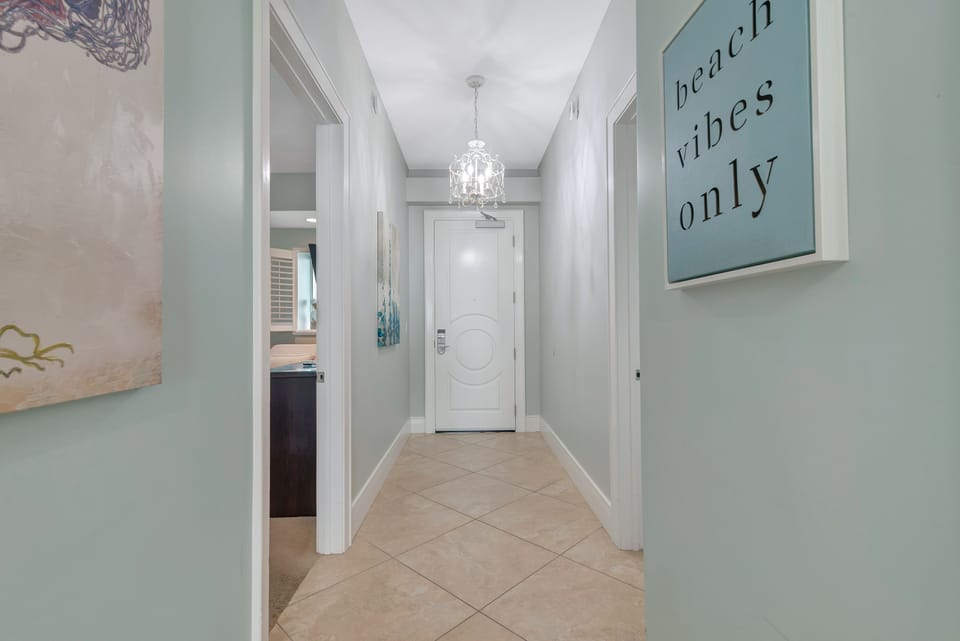 Welcome to Unit 1005-C, where the vacation begins. Step inside and immediately feel the beach vibes and sophisticated charm, complete with a dazzling chandelier that sets the tone for your luxury stay.
