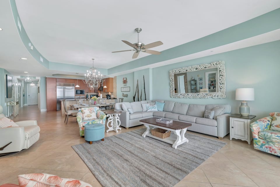 This expansive open-concept living area is designed for gathering and maximizing the stunning Gulf views. Enjoy the flow between the gourmet kitchen, elegant 8-seat dining area with chandelier, and the comfortable living room.