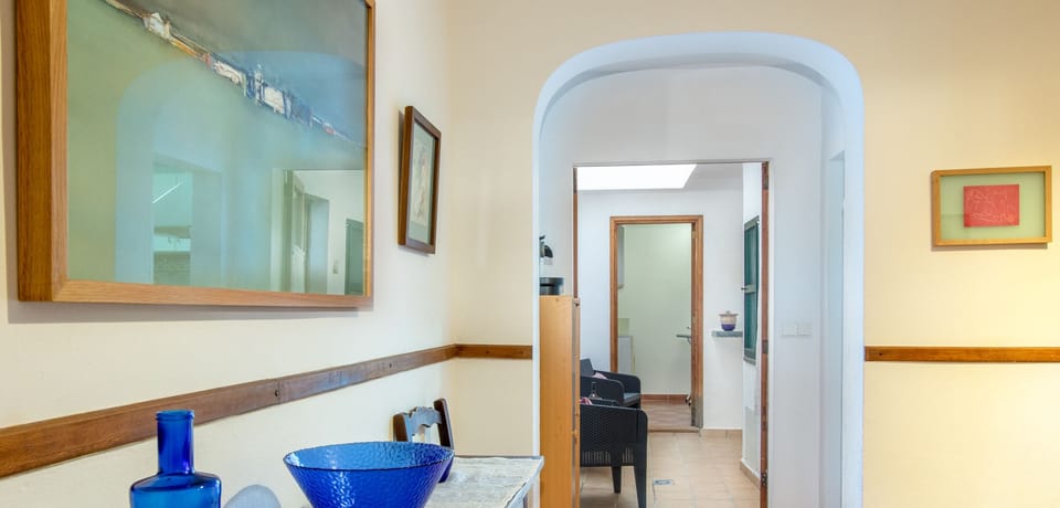 Interior hallway in a traditional Mallorcan village house with an arched doorway, terracotta floors and Mediterranean décor.