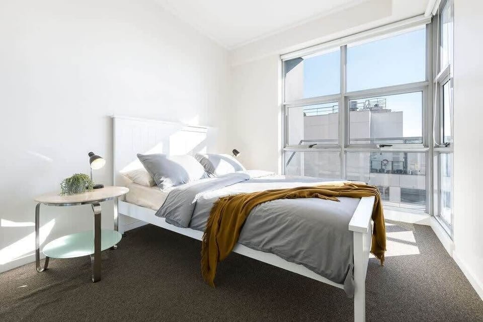 The second bedroom with a queen sized bed & plush pillows. *windows is under repair.