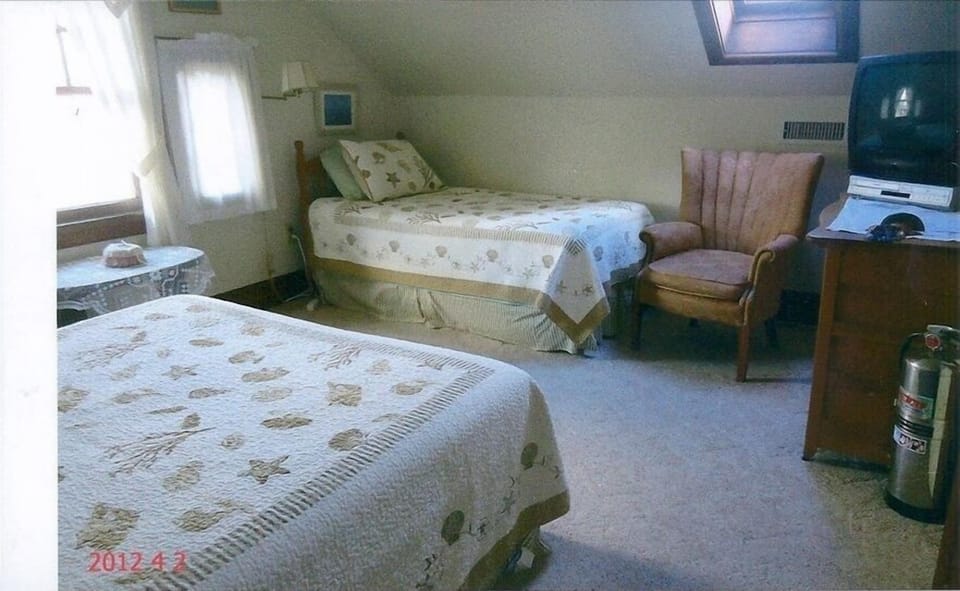 Another view of the bedroom with twin bed and queen bed along with TV/DVD.