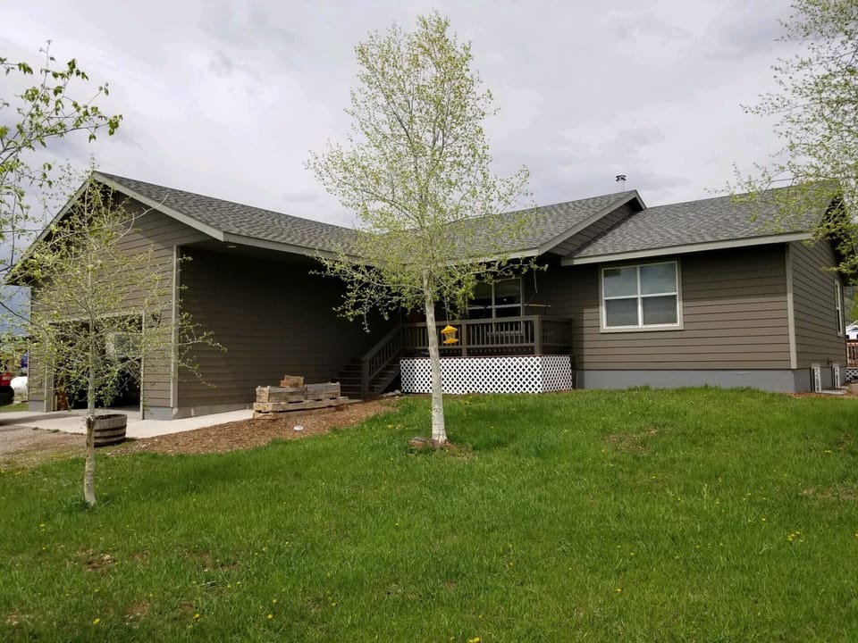 Front of house with porch and two-car garage.