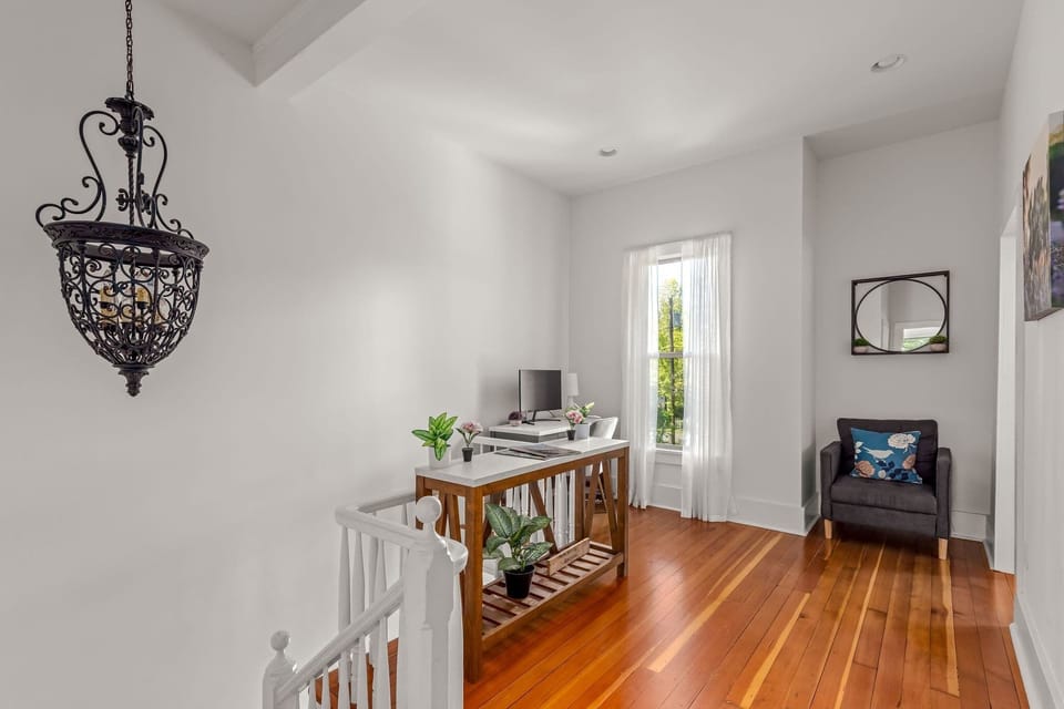 Bright upstairs landing with dedicated workspace, reading nook, and soaring ceilings.