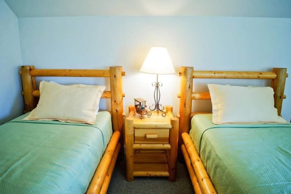 The third floor loft room features high ceilings and a cozy living area, as well as two twin bedrooms and an attached bathroom.