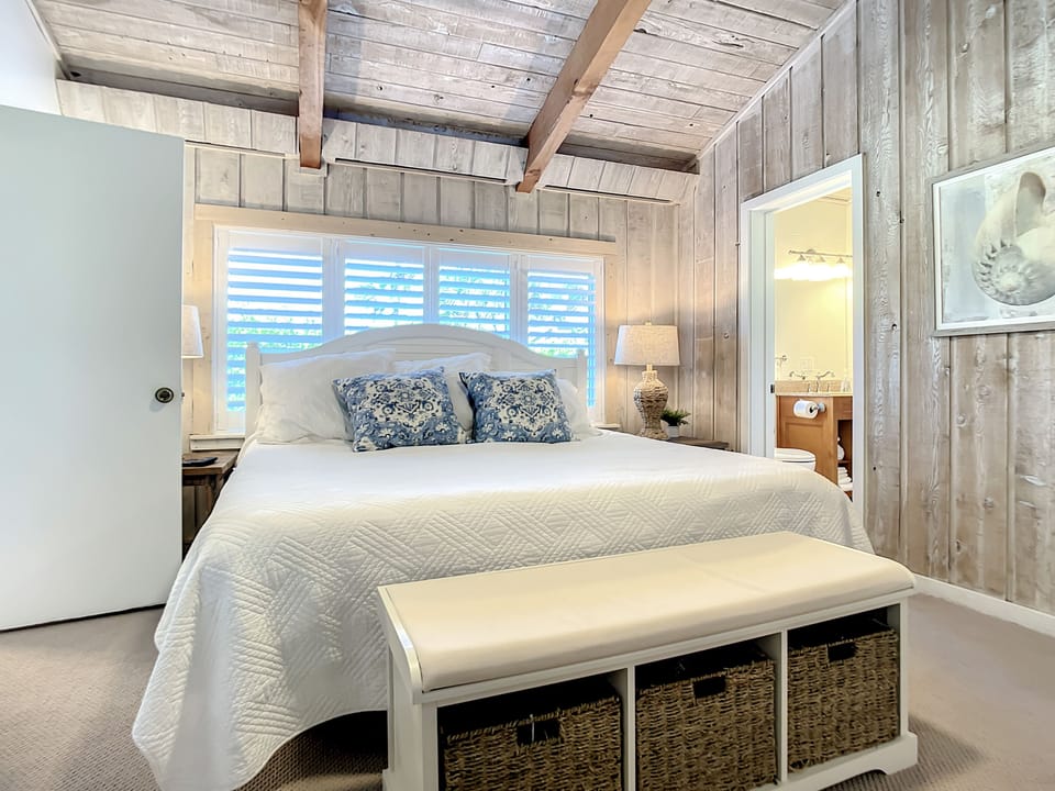 Master bedroom with a king-size bed and access to private bath with walk-in shower.