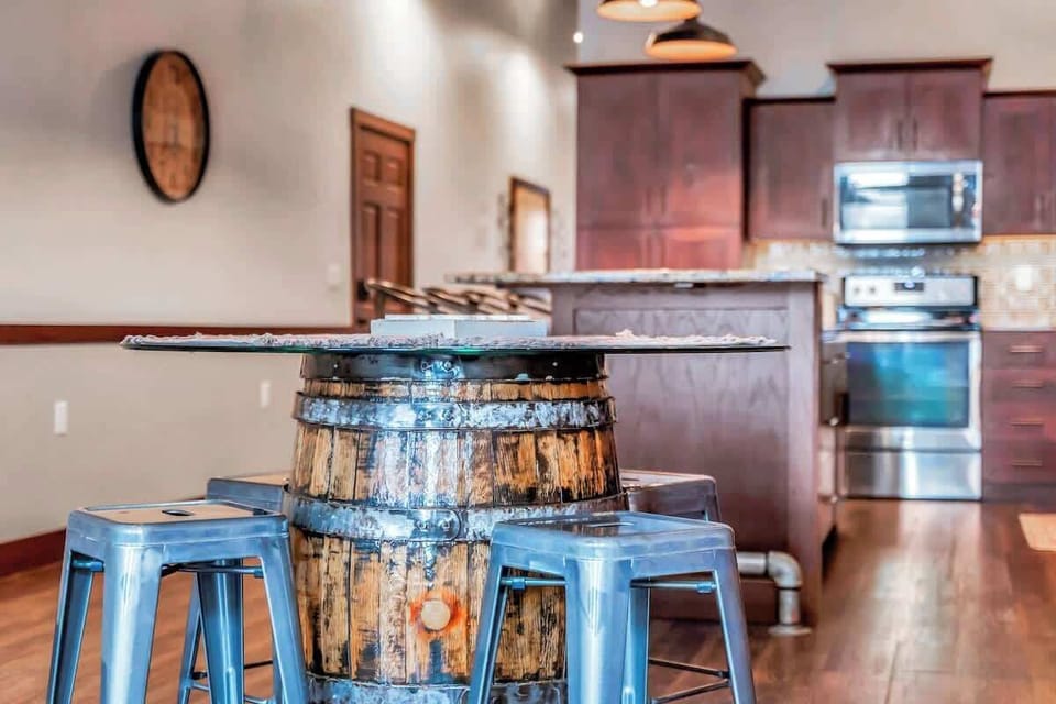restored bourbon barrel with glass table top. Exposed brick throughout apartment . 