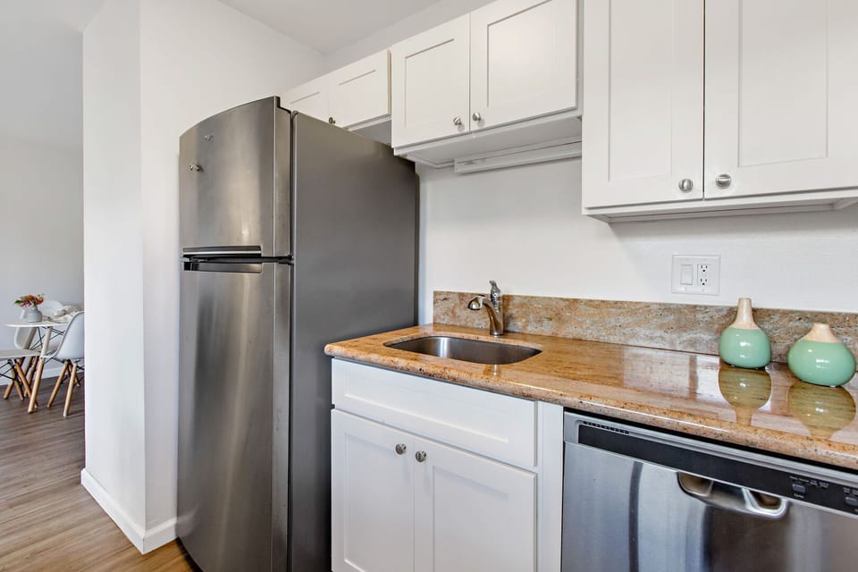Renovated kitchen with bright white cabinets and stainless steel appliances