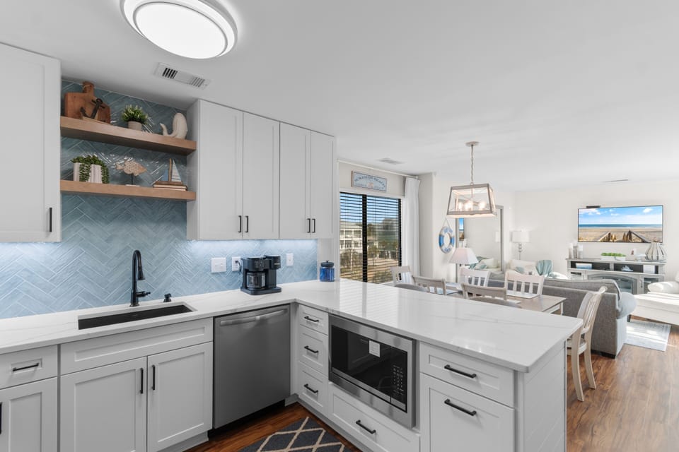 Your modern kitchen awaits with gleaming countertops, stylish blue subway tile backsplash, and all the appliances you need to create memorable meals together.