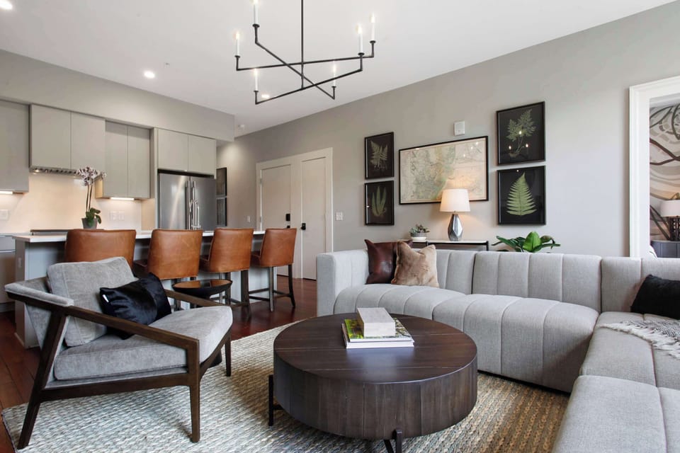Living Room | Seating Area with Round Coffee Table and Natural Light | Fourth Floor of Building — Unit on One Level
