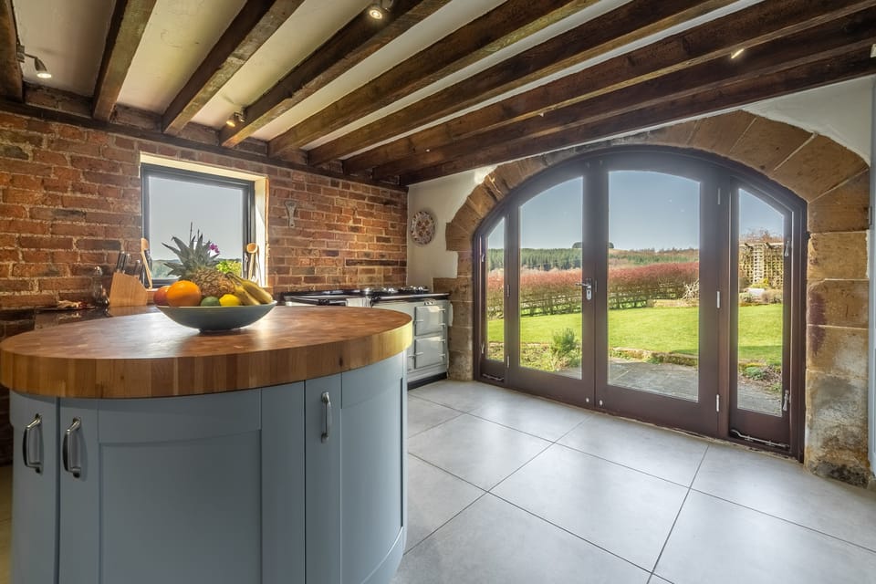 Ground floor: Kitchen with circular island and arched doorway to garden