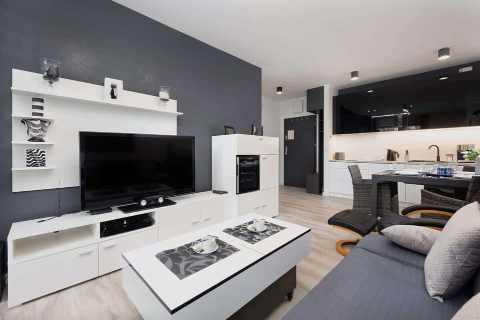 Another view of the main living area, emphasizing the spaciousness and modern decor. The sectional sofa and monochrome palette give a sleek and stylish look.