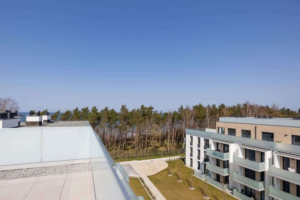 A similar angle of the complex exterior with a focus on the landscaped areas and the building's contemporary architecture.