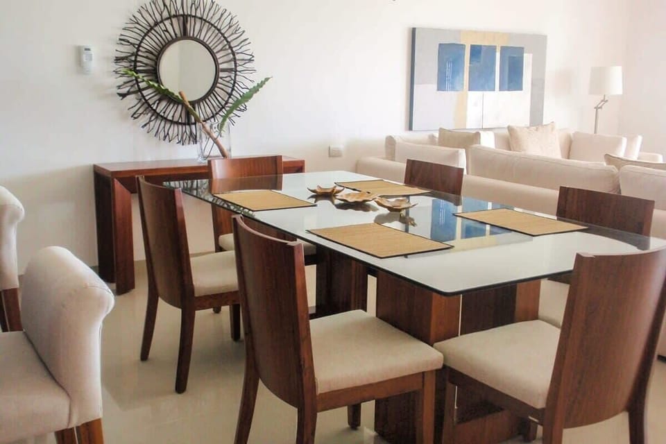 Modern dining area with a glass-top table and wooden chairs for comfortable family meals.