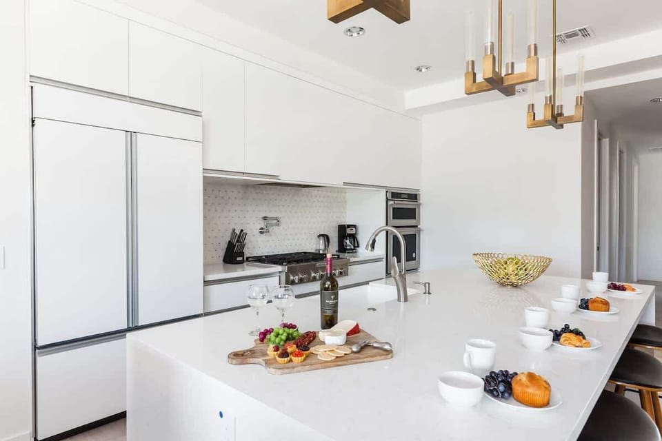 Fully Equipped Chefs Kitchen stocked with all culinary essentials, and stainless steel appliances. Features an oversized island with breakfast bar seating.