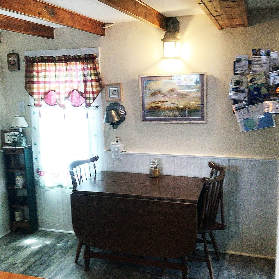 Drop leaf maple dining table in kitchen. Bulletin board has area info for you.