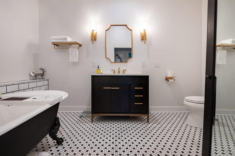 Bathroom vanity with gold accents and clawfoot tub