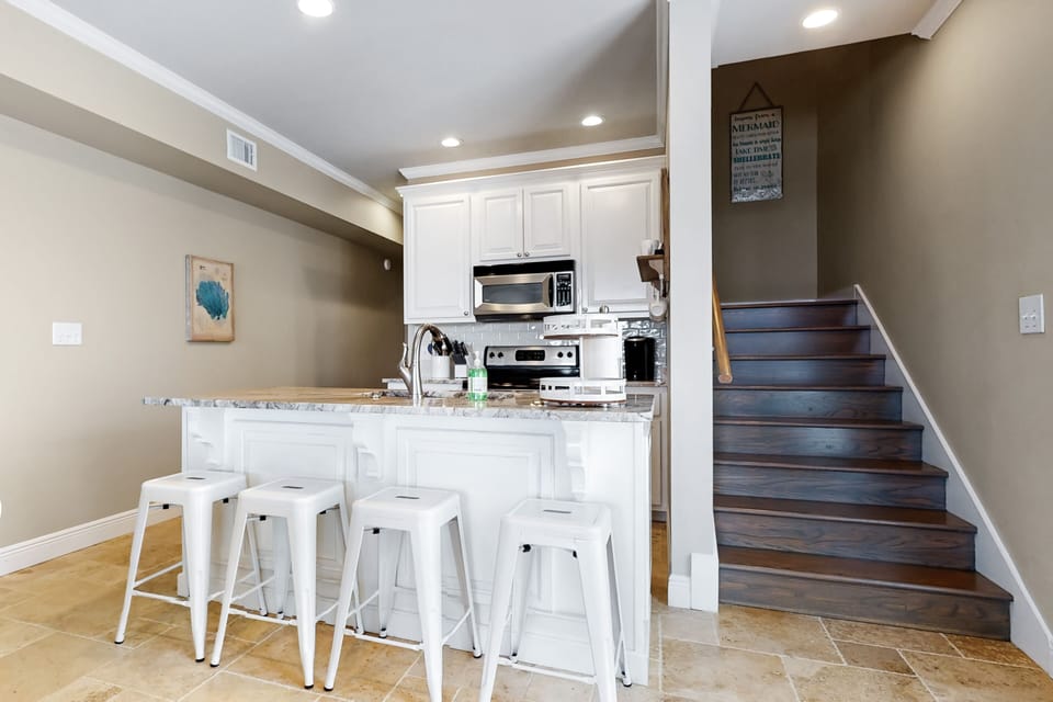 Kitchen and bar area with 4 barstools.