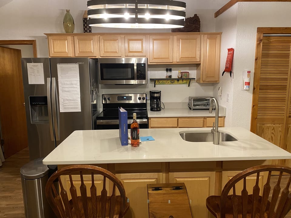 Fully stocked kitchen with fridge, oven, microwave, dishwasher.