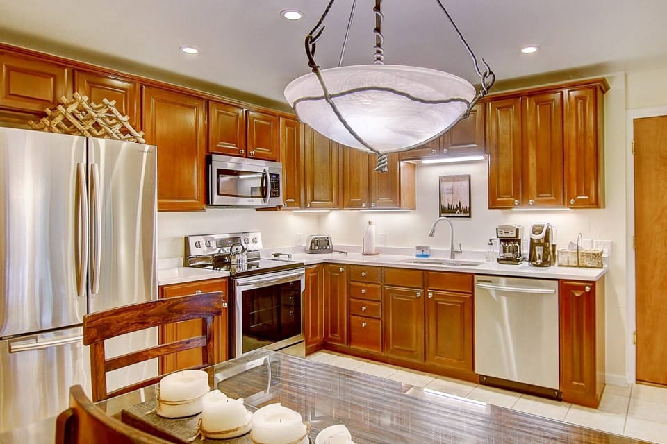 Bright open kitchen with sleek finishes, fully stocked for every meal—plus a peek at the inviting dining area nearby.