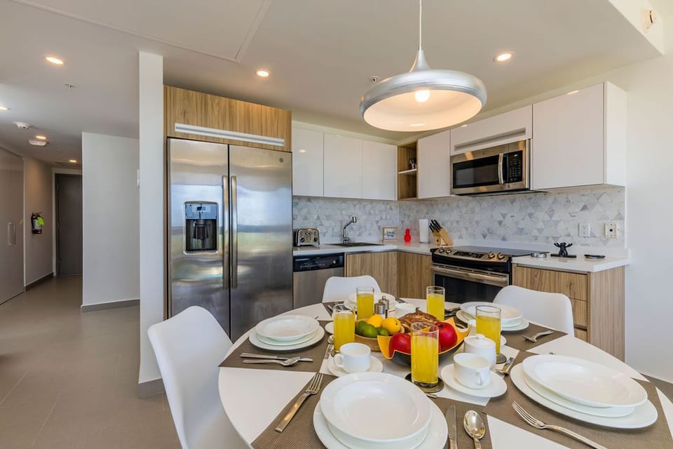 Gather around this sleek dining space for morning meals and evening feasts. Your modern kitchen features stainless steel appliances, marble backsplash, and everything needed to create culinary memories together.