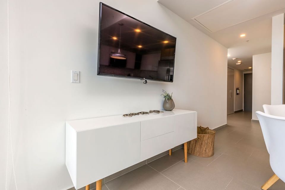 Settle in and unwind in this bright, modern living space with a wall-mounted TV and sleek storage for your belongings.