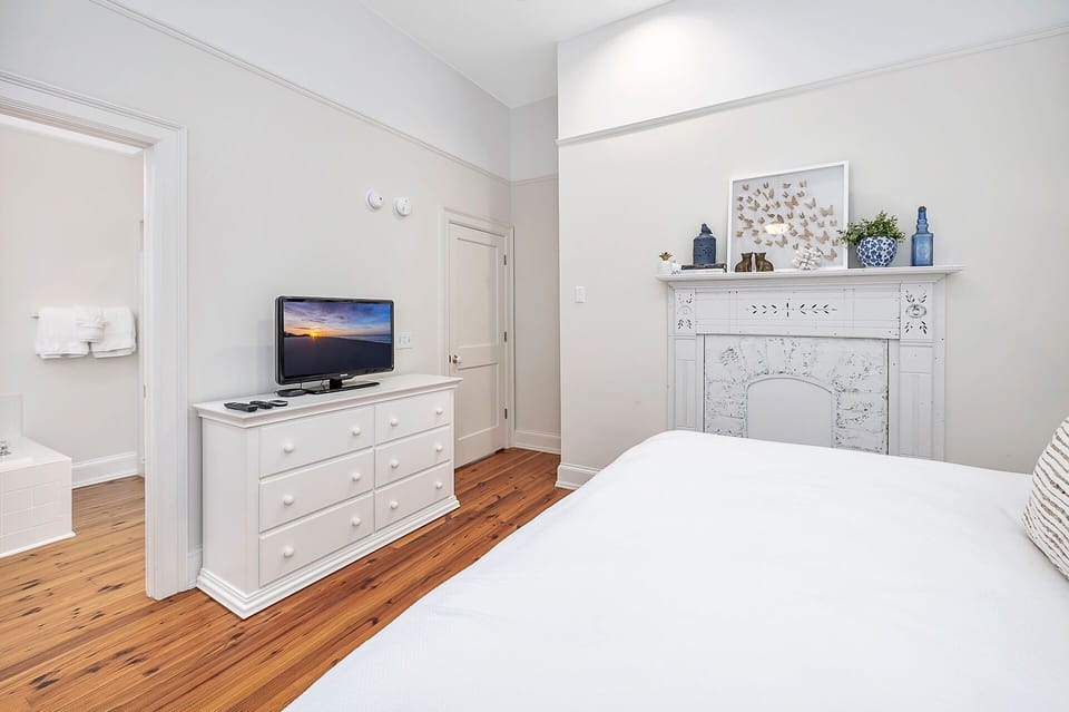 The open and airy Primary Bedroom has a king-sized bed and en suite bathroom.