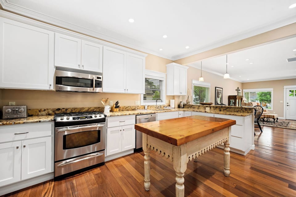 Your spacious kitchen features granite countertops, stainless steel appliances, and a charming wooden island perfect for preparing memorable meals during your stay.