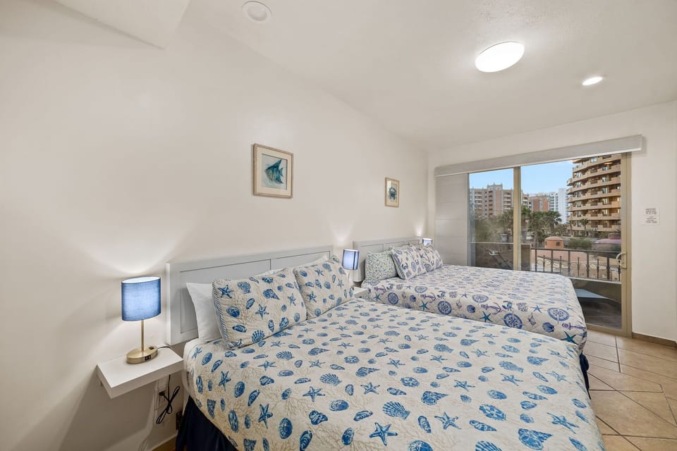 Guest bedroom with one king and one queen bed plenty of space and comfort for couples, kids, or group travelers.