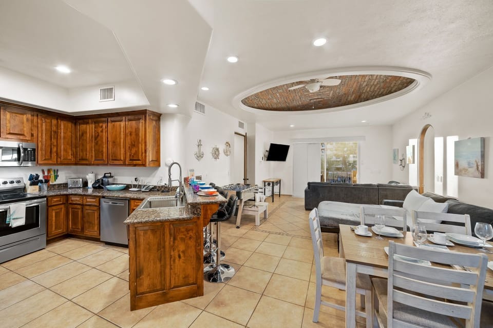 Fully stocked kitchen with stainless steel appliances and breakfast bar—cook, dine, and entertain with ease.