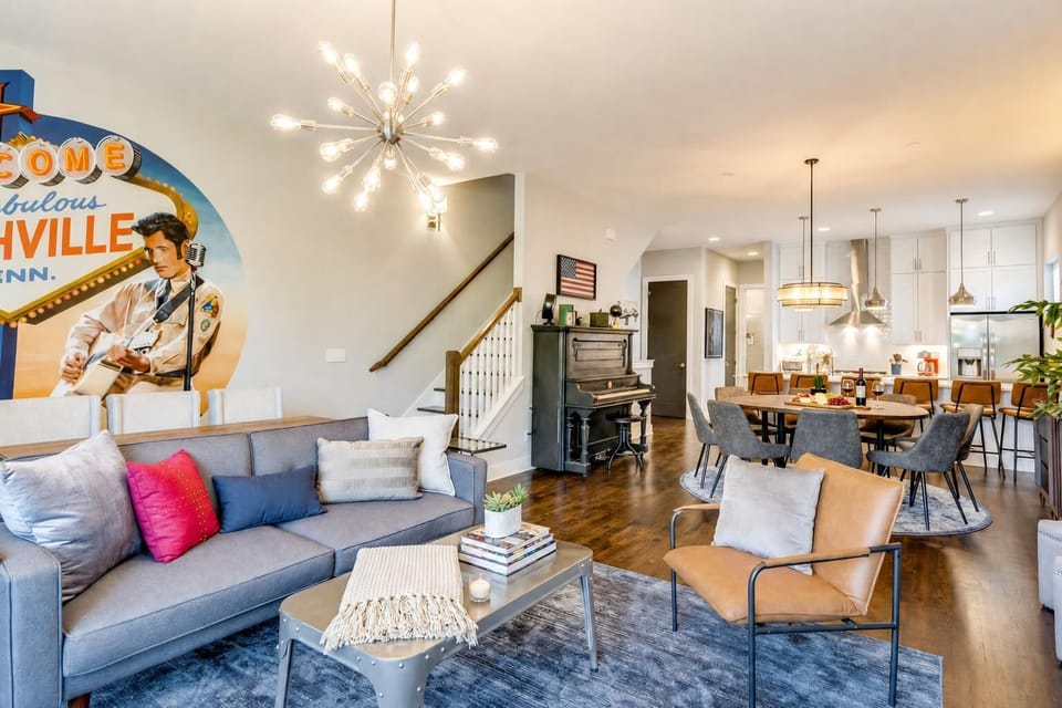 The open living room and dining area center around an upright piano and a 'Nashville' sign, the kind of layout that actually keeps groups gathered instead of scattered