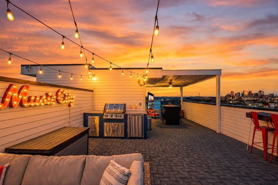 Grill sizzling, Music City sign glowing, sectional sofa facing the downtown skyline at sunset, your crew and the Nashville horizon, that is all you need