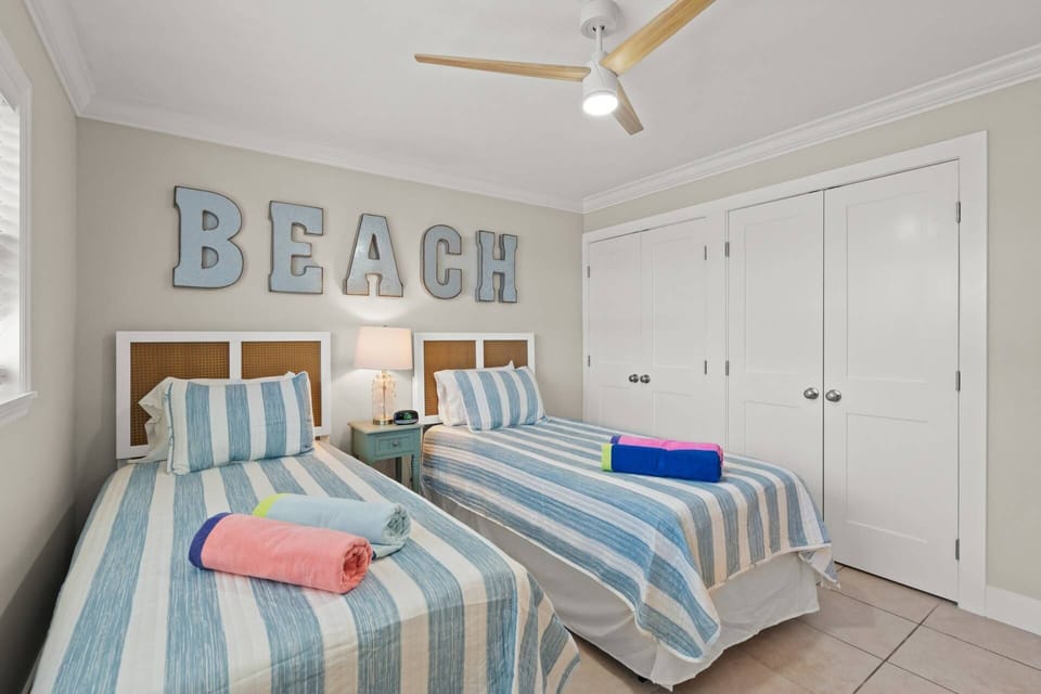 Adorable guest bedroom with twin beds and closets for your use. There is also a small dresser with a TV.