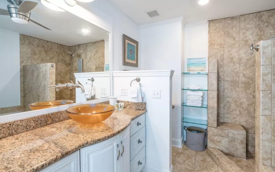 Indulge in this spa-like bathroom with stunning vessel sinks, granite counters, and your own private walk-in shower with natural stone tiles.