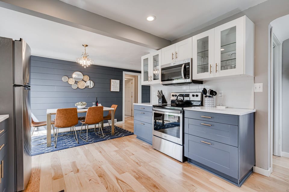 Your modern kitchen flows seamlessly into the dining area, featuring sleek two-tone cabinetry and stainless steel appliances perfect for cooking memorable meals.