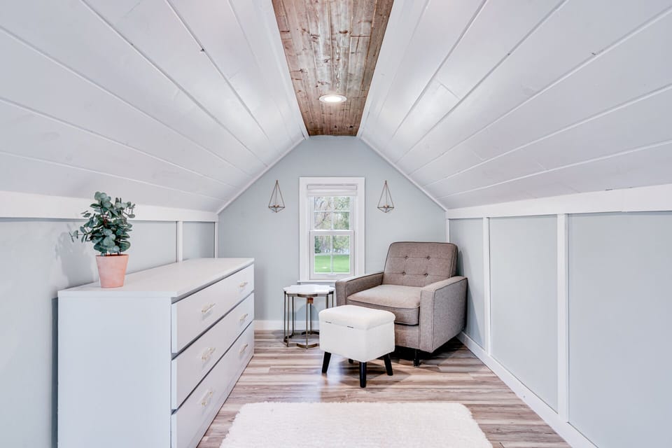 Your peaceful attic retreat features vaulted ceilings, cozy seating, and charming storage—perfect for unwinding with a book.