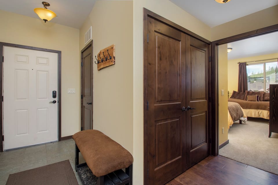 Step into your welcoming entryway with convenient boot storage and rich wood details leading to your cozy bedroom retreat.