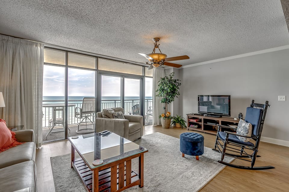 Large living space with flat-screen TV and balcony access