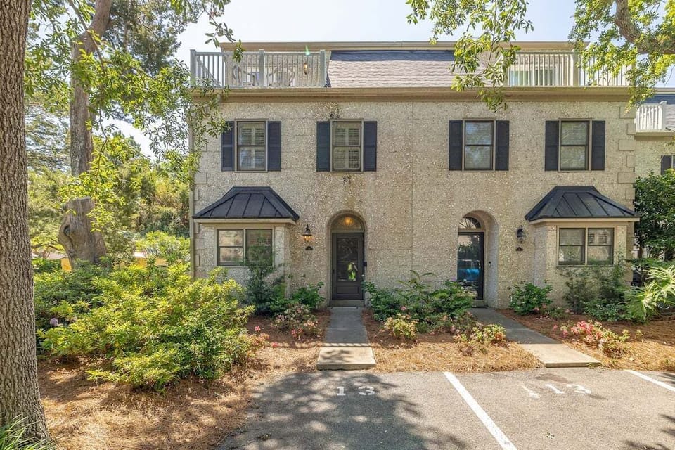 Exterior of multi-story property with arched entry and shutters