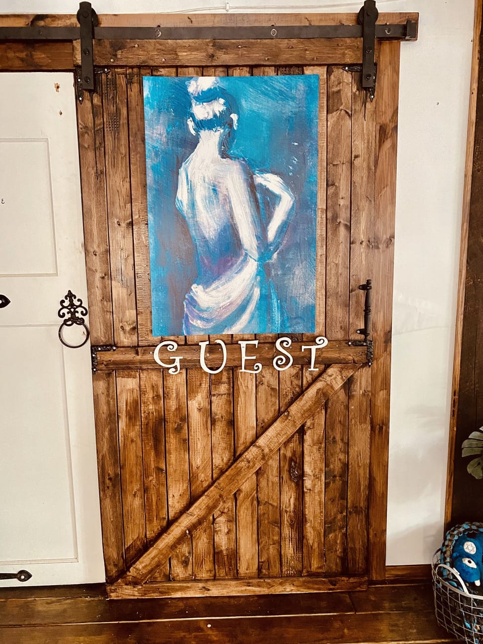 No mistaken this door as a bathroom entrance with a beautiful art piece and sign