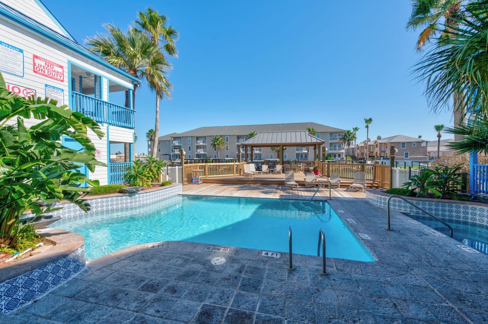 Tropical paradise awaits with crystal-clear pool surrounded by swaying palms and sunny deck space for your perfect getaway.