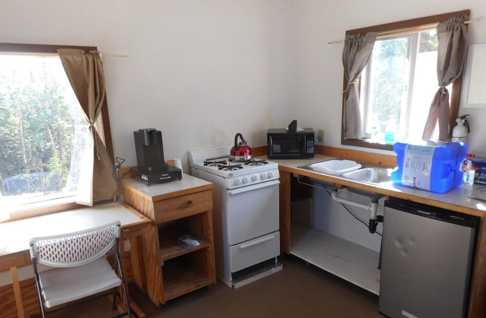 Kitchen with sink, small ref, microwave, propane cook stove, Keurig coffee maker