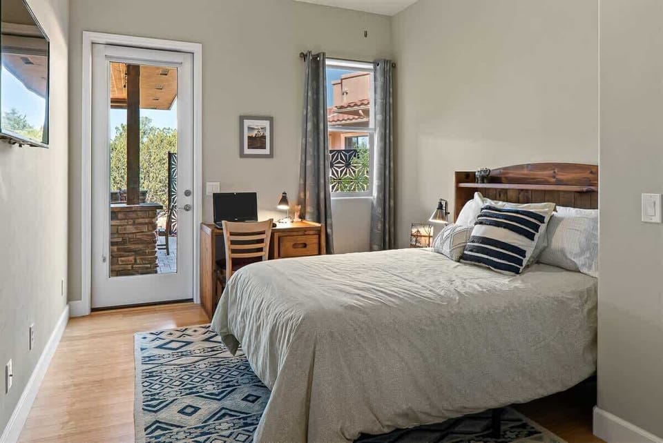 Bedroom 3 has a double bed with a workspace and access to the back patio