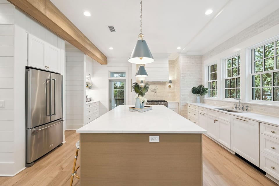 Your stunning chef's kitchen features marble countertops, premium stainless steel appliances, and abundant natural light streaming through charming windows.