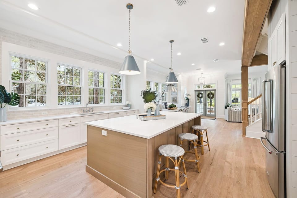 Your gourmet kitchen awaits with marble countertops, spacious island seating, and sunlight streaming through garden-view windows.