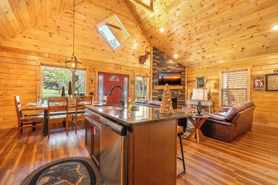 Gather around the granite island in your cozy cabin kitchen, where rustic charm meets modern convenience for memorable meals together.
