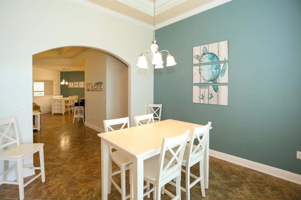 - Gather the whole group in this charming dining space with seating for six & a relaxed beach vibe - Coastal turtle art piece & soft teal accent wall bring a pop of personality - Ideal for family dinners, card games, or planning the next day's advent