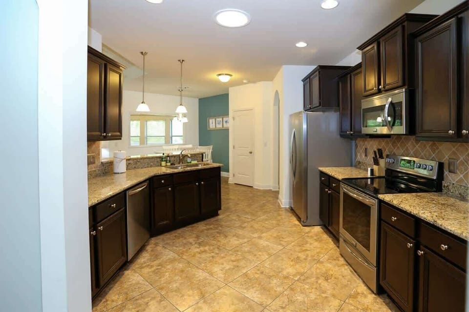 - Spacious, fully stocked kitchen with modern stainless steel appliances - Generous counter space, dark wood cabinetry, & all the tools you need to feel right at home - Whether it’s a family meal or a midnight snack, this kitchen is ready for any cra