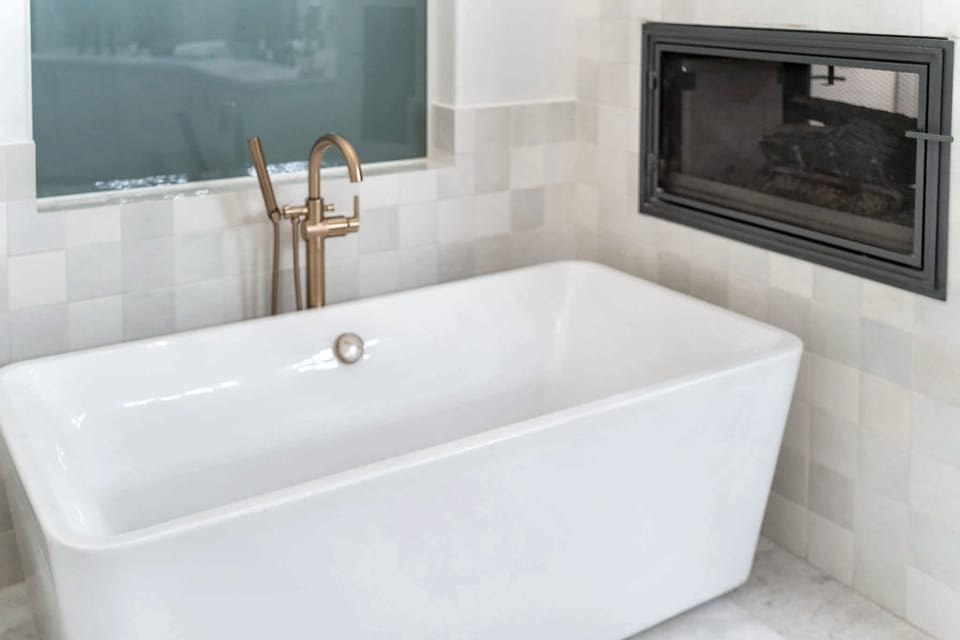 Primary en-suite bathroom soaking tub and two-way fireplace