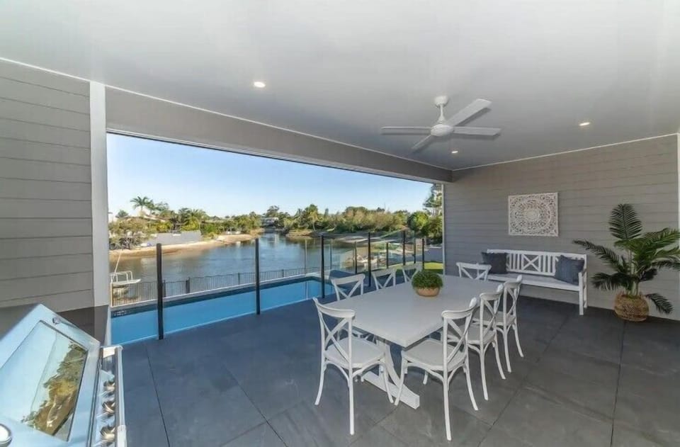 BBQ alfresco area overlooks the heated pool, yard and canal.